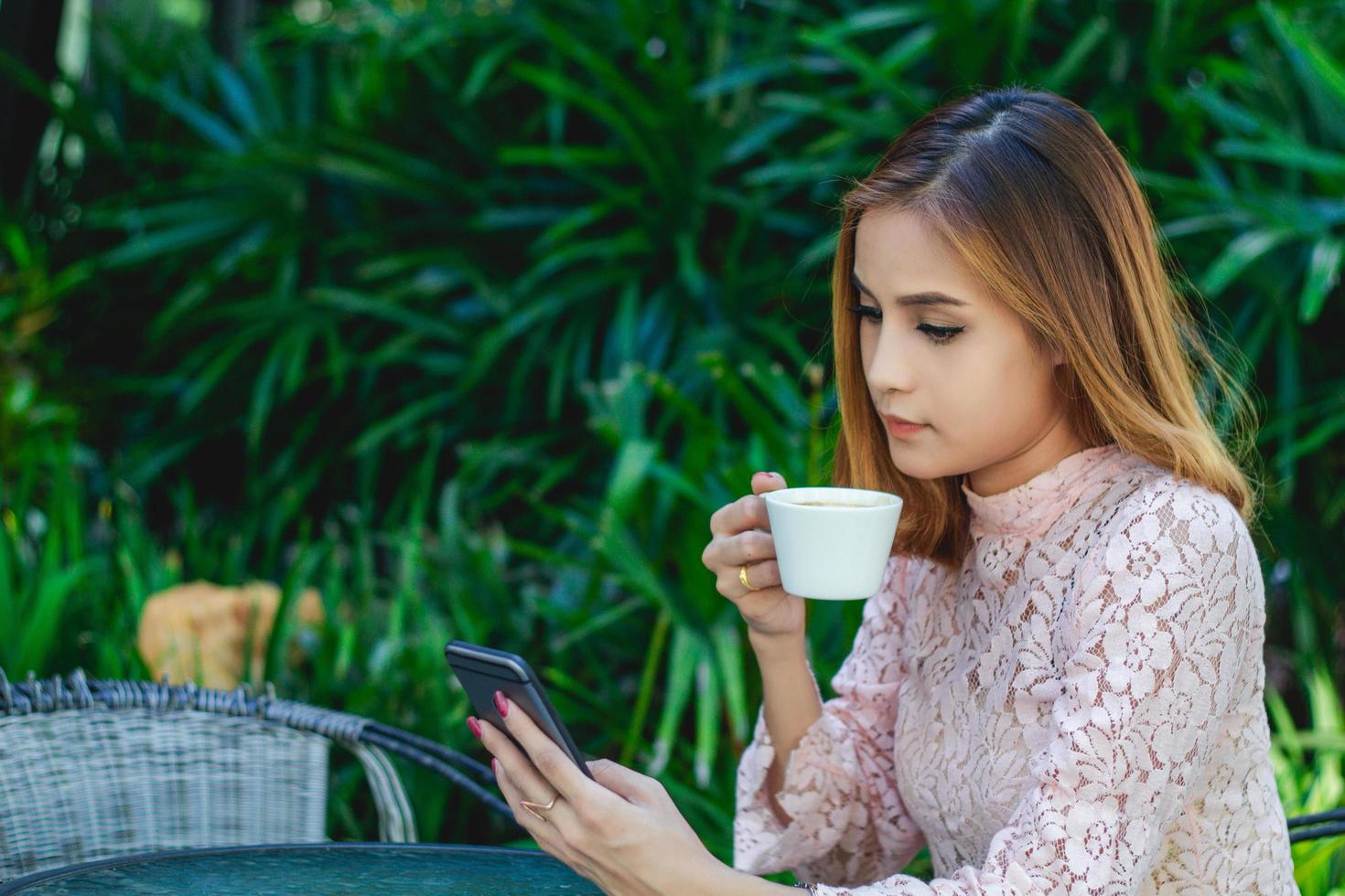 hombres y mujeres de negocios están usando teléfonos inteligentes móviles y táctiles para comunicarse y controlar a la gente de negocios en el fondo de la oficina foto