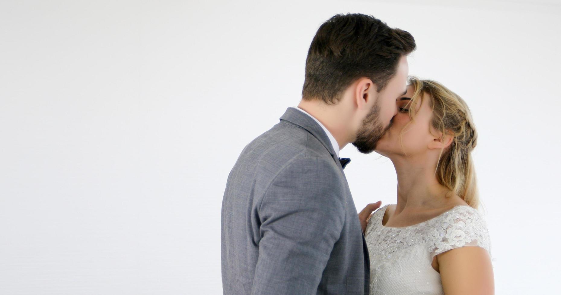 The lovers give flowers to the bride and kissed happy and couple love standing in wedding studio photo