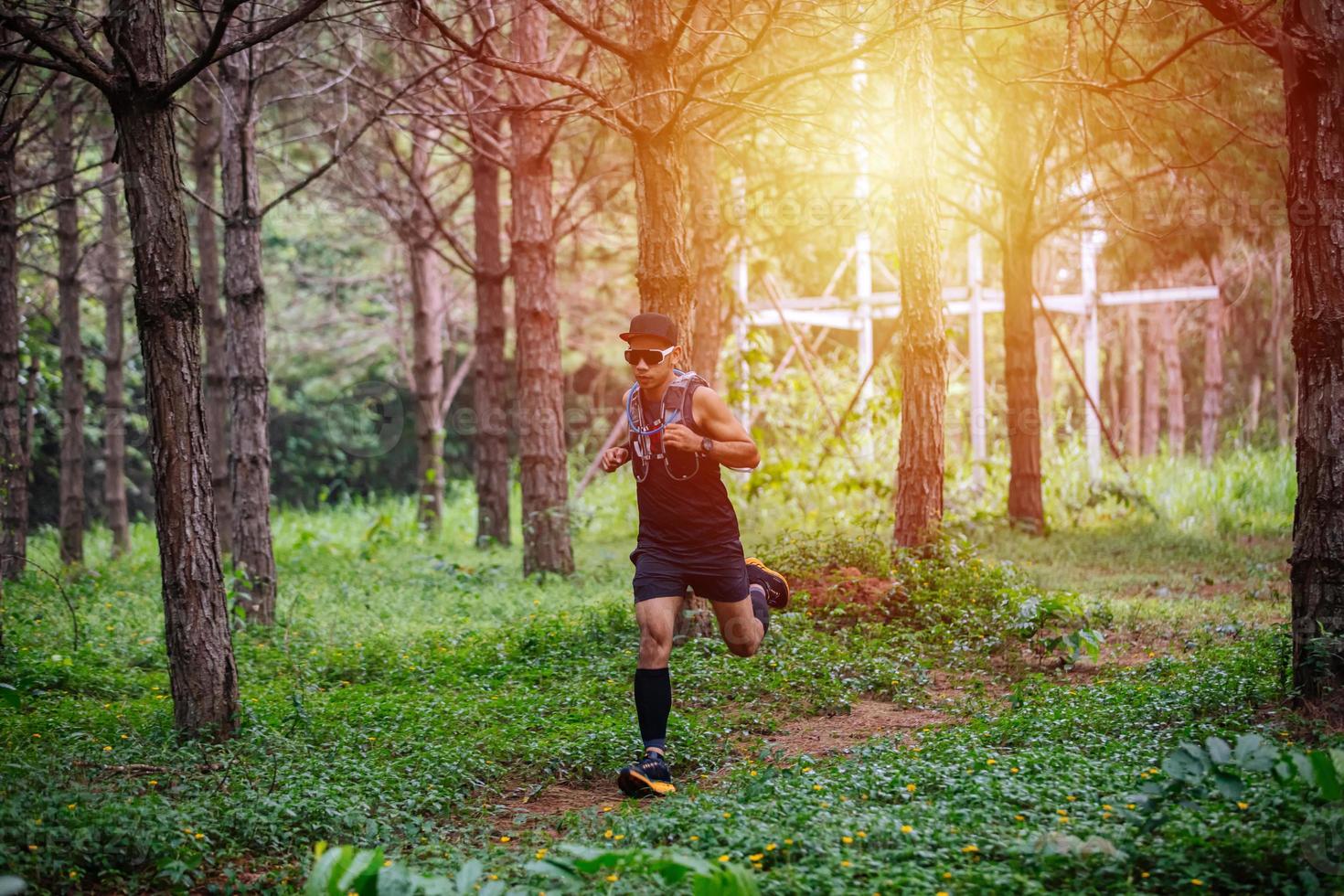 A man Runner of Trail and athlete's feet wearing sports shoes for trail running in the forest photo