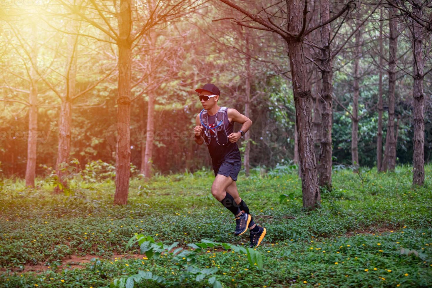 A man Runner of Trail and athlete's feet wearing sports shoes for trail running in the forest photo