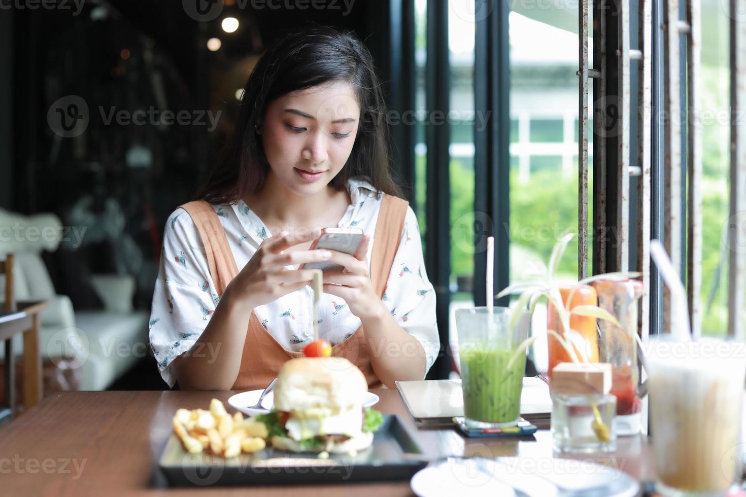 Mujeres asiáticas sonrientes y felices y disfrutaron comiendo hamburguesas en el café y el restaurante en el momento de relajarse foto