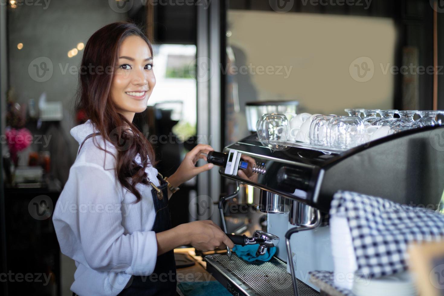 Asian women Barista smiling and using coffee machine in coffee shop counter - Working woman small business owner food and drink cafe concept photo