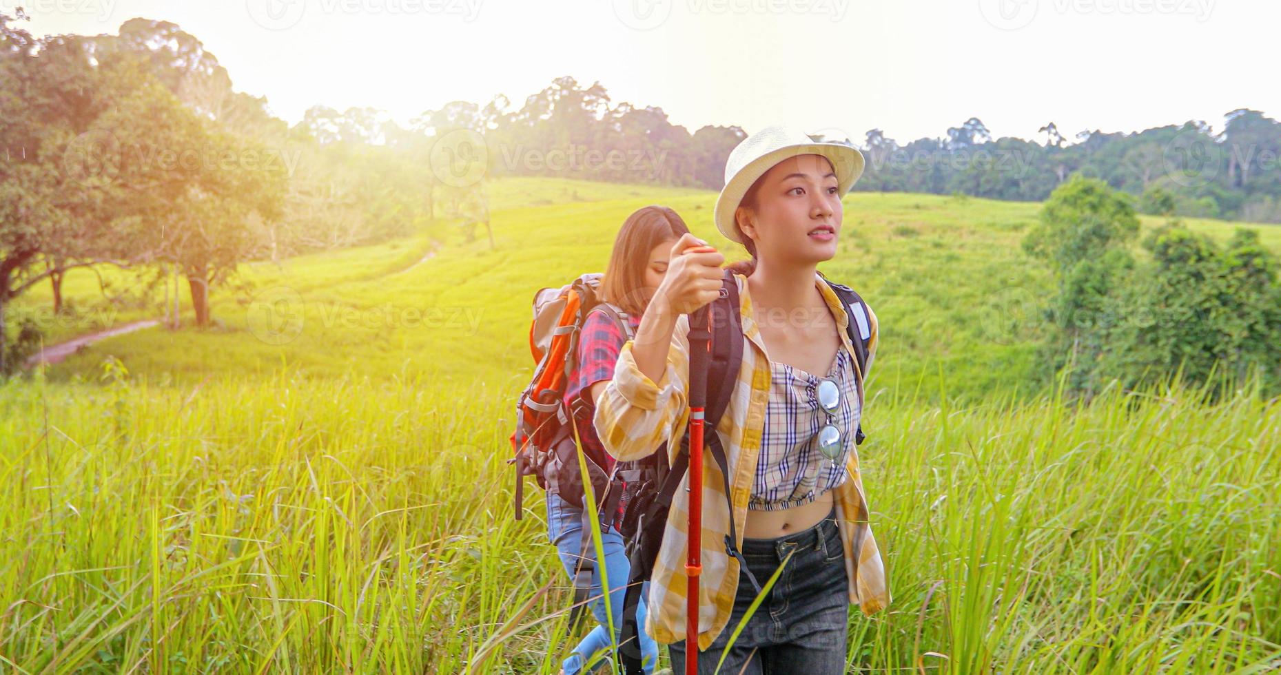 Asian Group of young people Hiking with friends backpacks walking together and looking map and taking photo camera by the road and looking happy ,Relax time on holiday concept travel