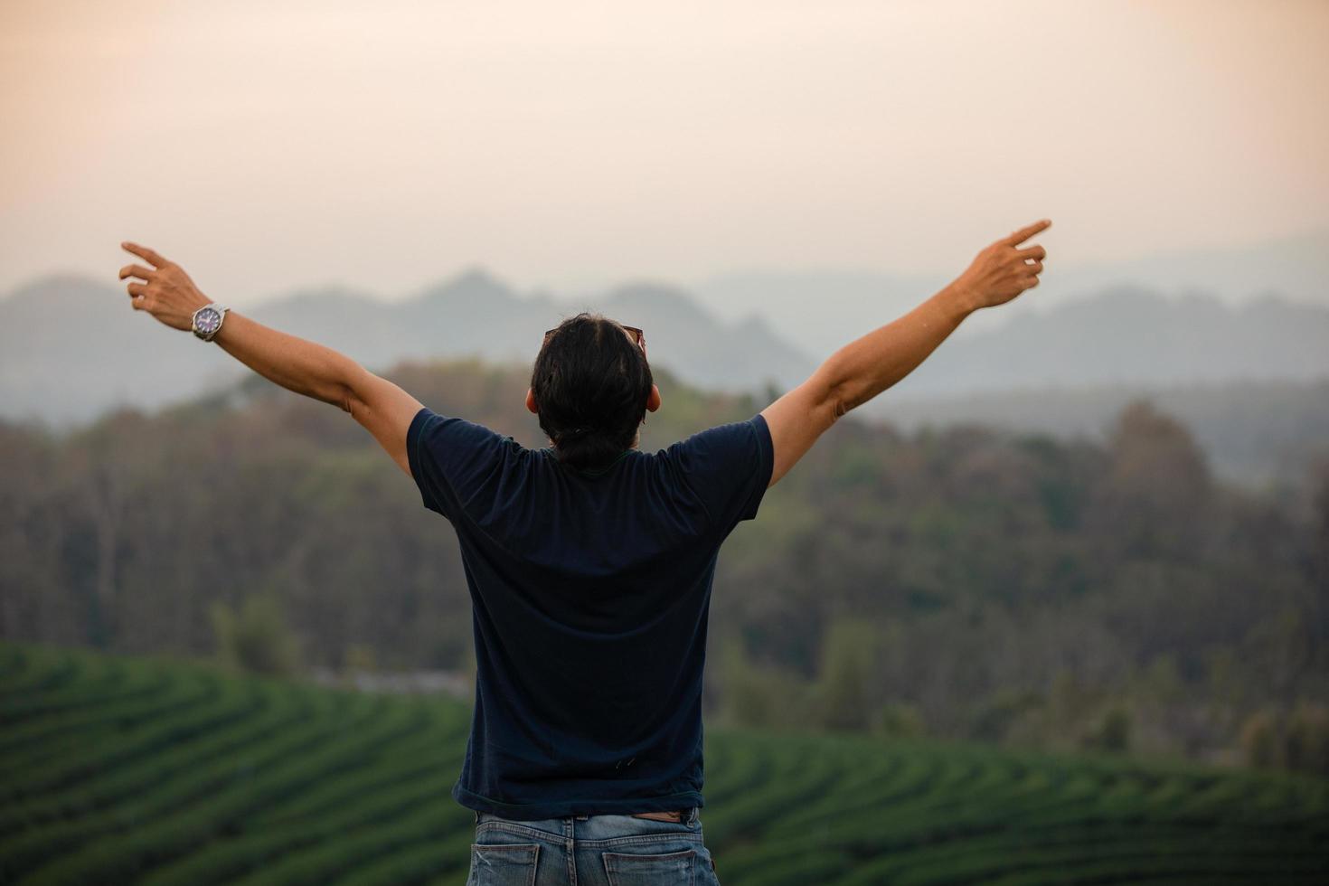 Freedom traveler men standing with raised arms and enjoying a beautiful nature and cheering young at sunset,Relax time on holiday concept travel photo