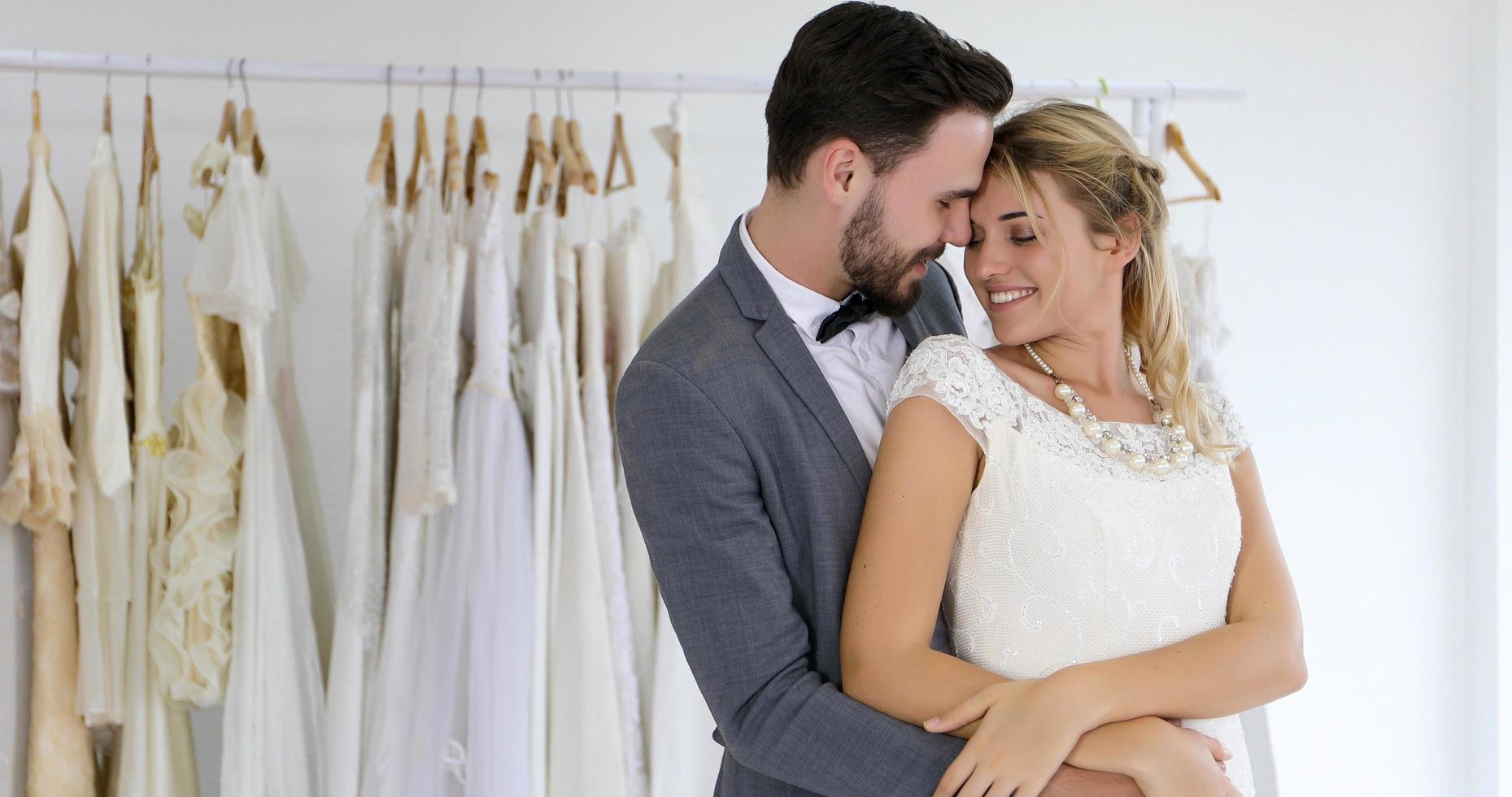 The lovers give flowers to the bride and kissed happy and couple love standing in wedding studio photo