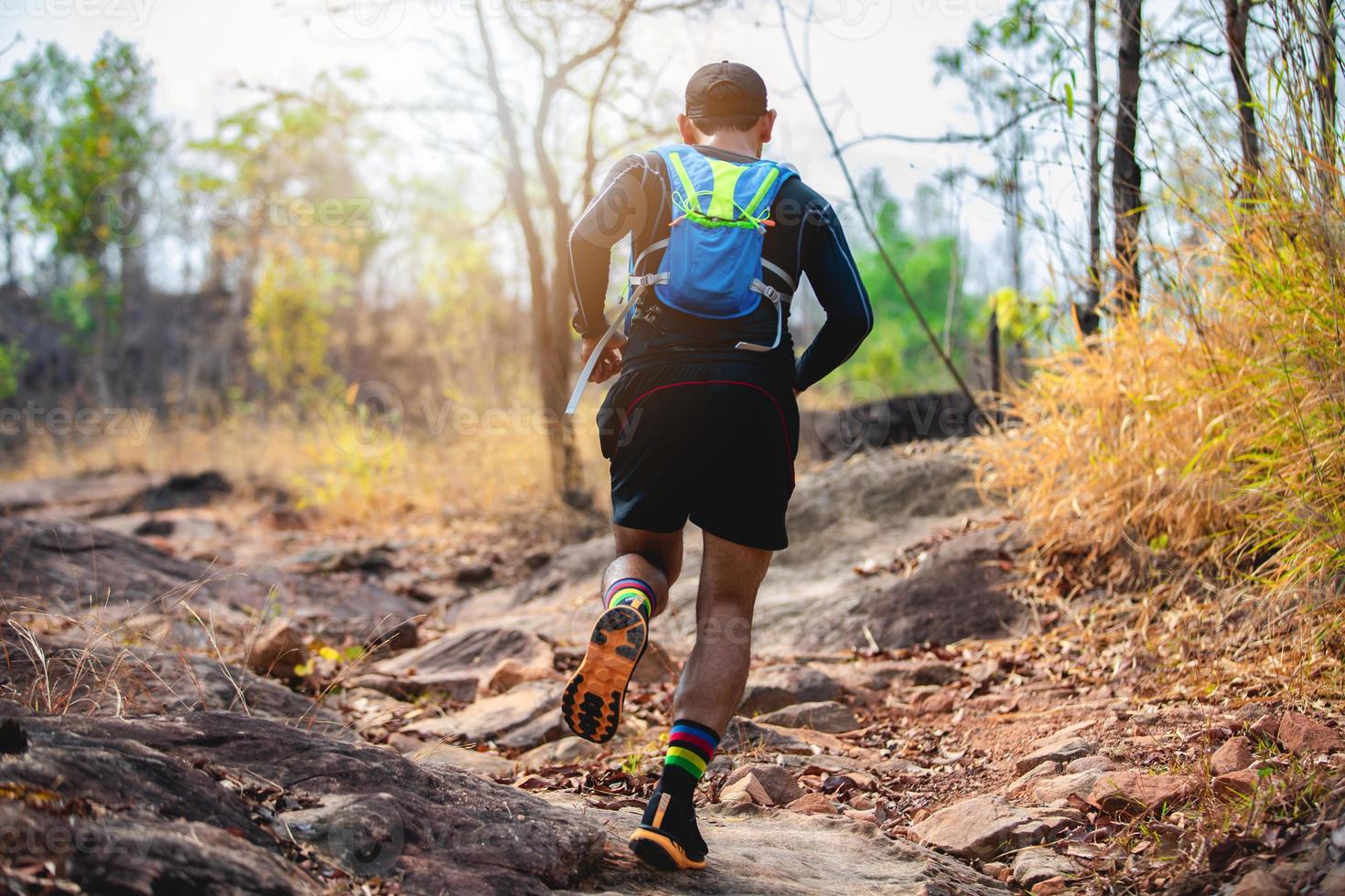 A man Runner of Trail . and athlete's feet wearing sports shoes for trail running in the forest photo