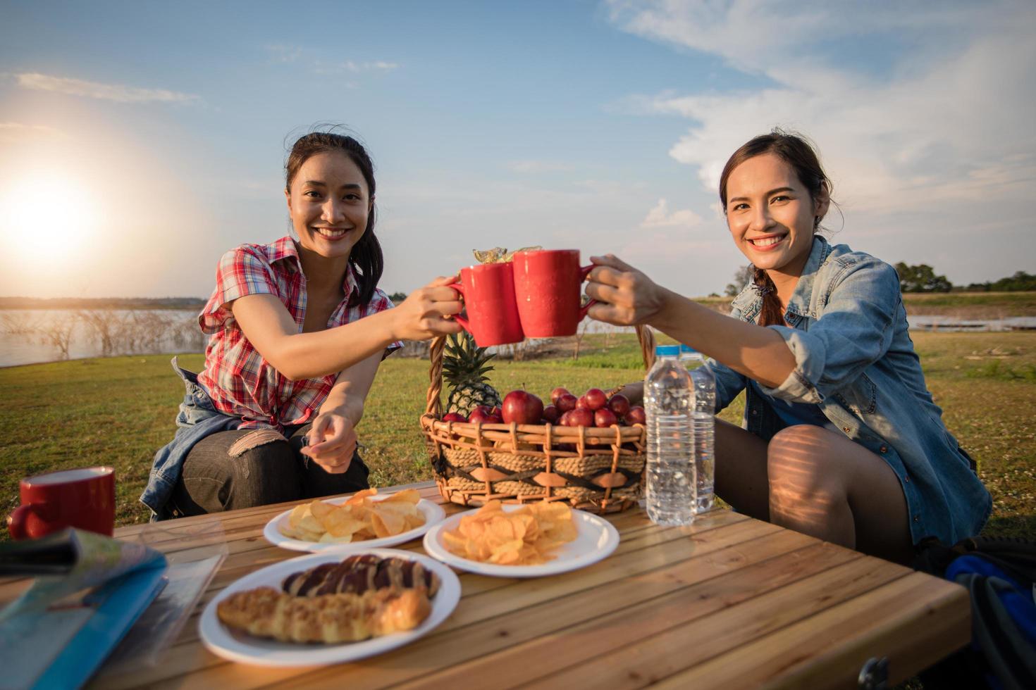 A group of Asian friends drinking coffee and spending time making a picnic in the summer holidays.They are happy and have fun on holidays. photo