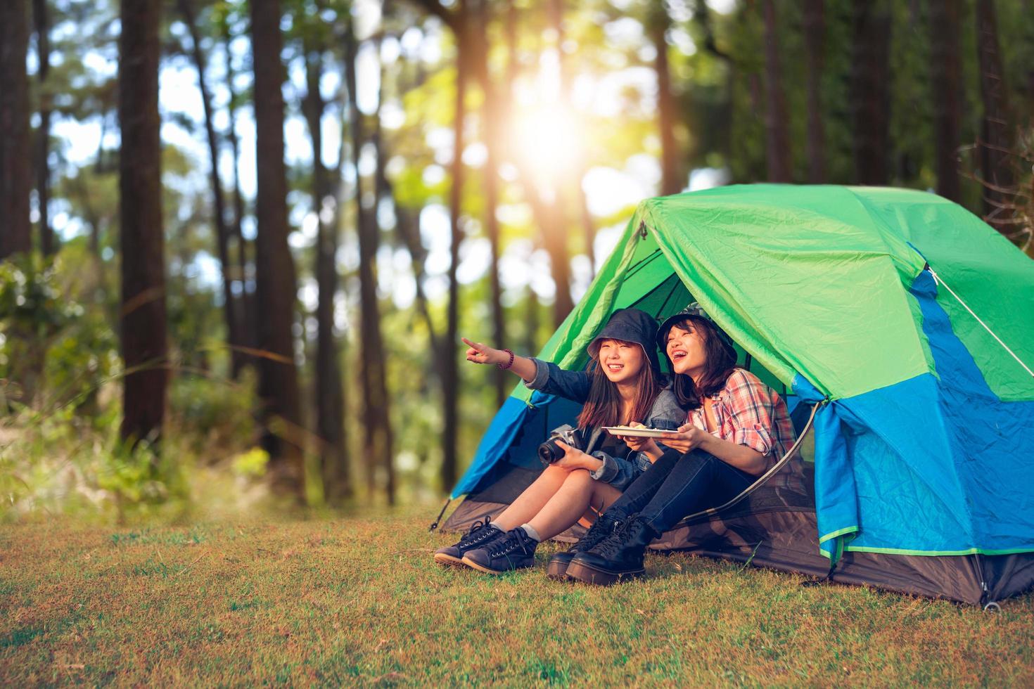 A group of Asian friends tourist drinking together with happiness in Summer while having camping photo