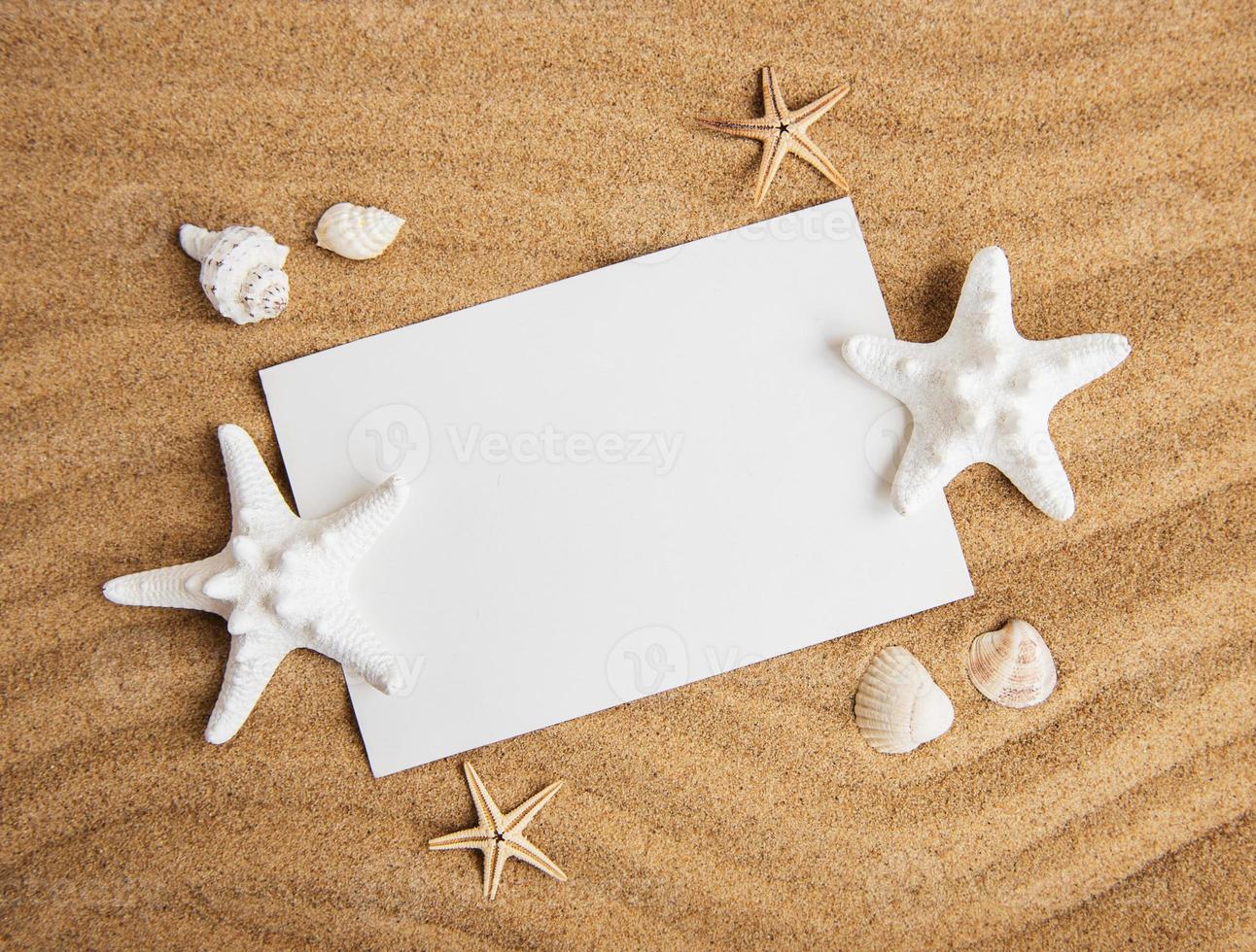 conchas, estrellas de mar y una postal en blanco foto