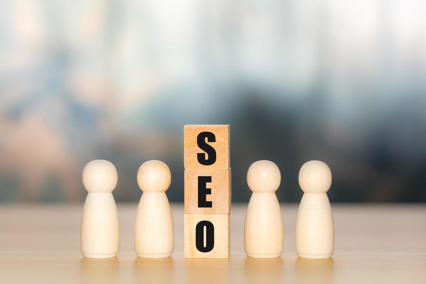 Concept of SEO. Text of search engine optimization or SEO on wooden cube block with the wooden figure. Searching, increasing sales channels, selling online, optimizing websites and products. photo