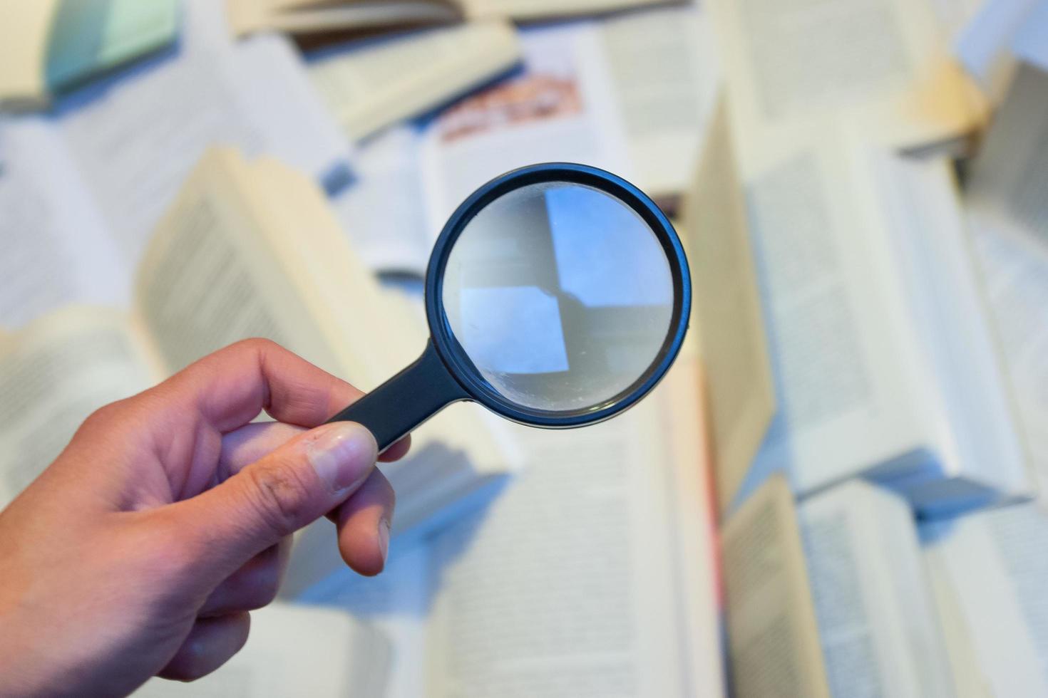 Magnifying glass to check various books photo