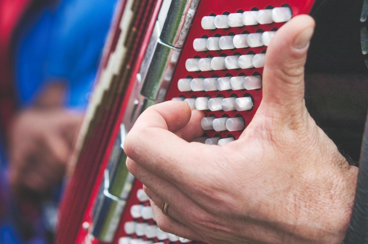 Detail of fingers on bass keys on an accordion photo