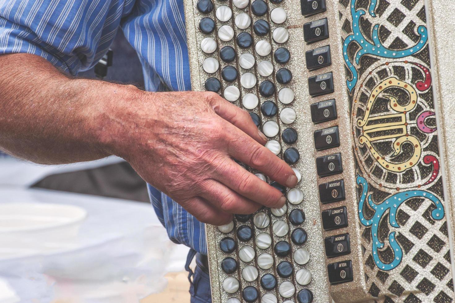 Hand detail of elderly person playing chromatic accordion photo