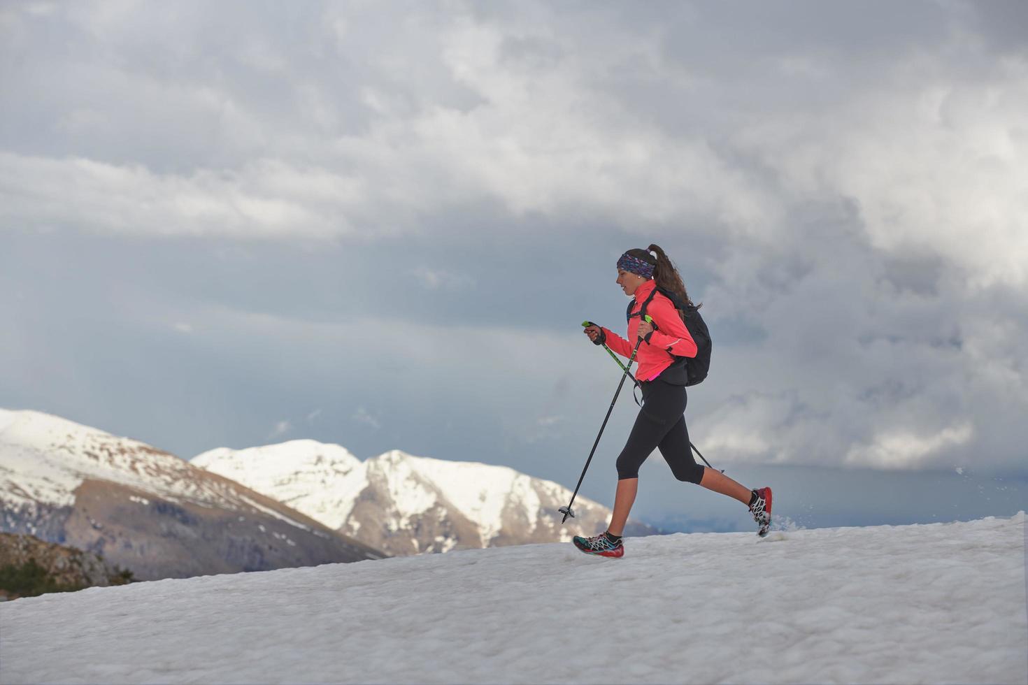 mujer atleta corre en la nieve para practicar skyrunning foto