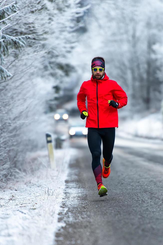 hombre durante un entrenamiento en una carretera helada en invierno foto