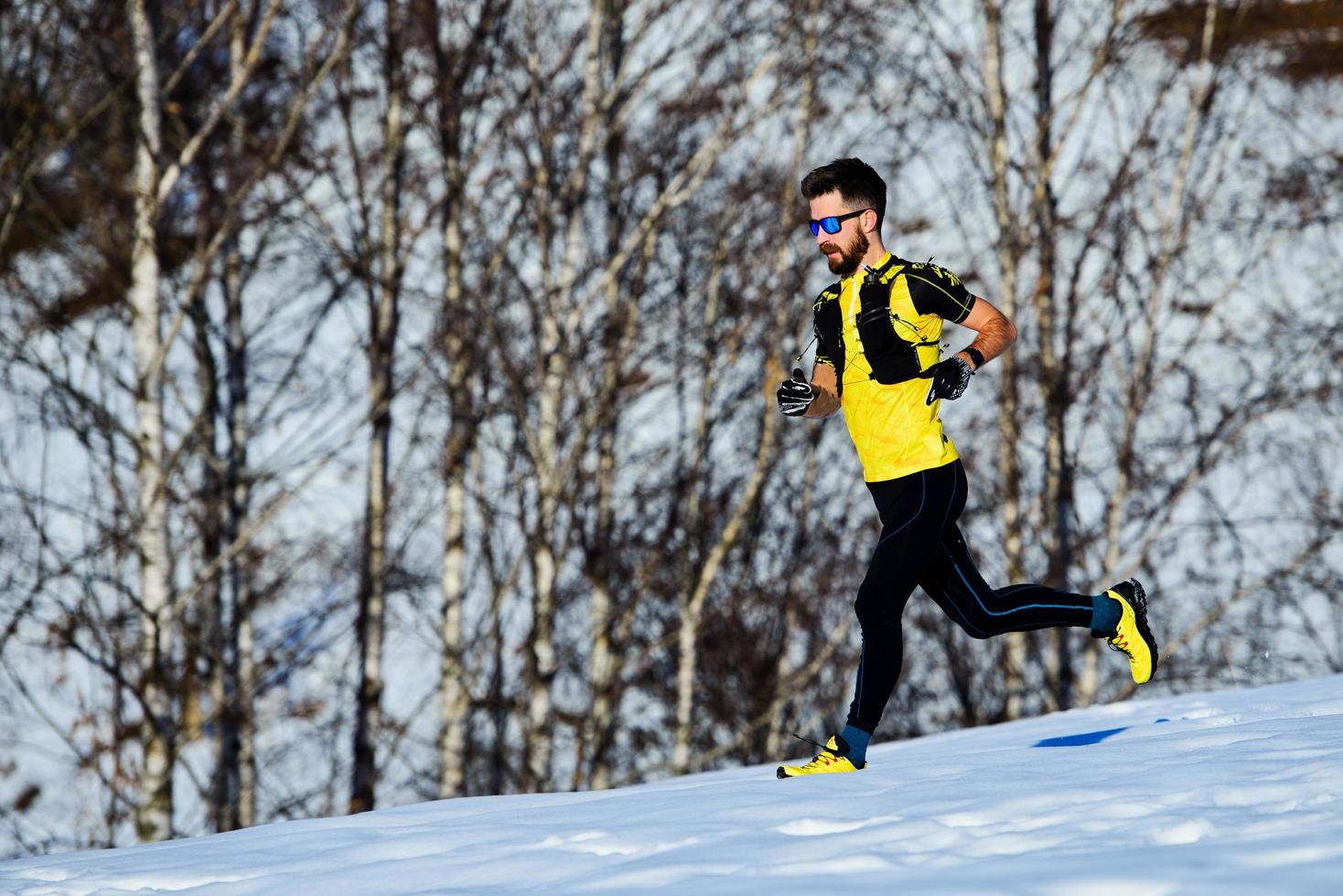 corriendo entrenando en la nieve un atleta cuesta abajo foto