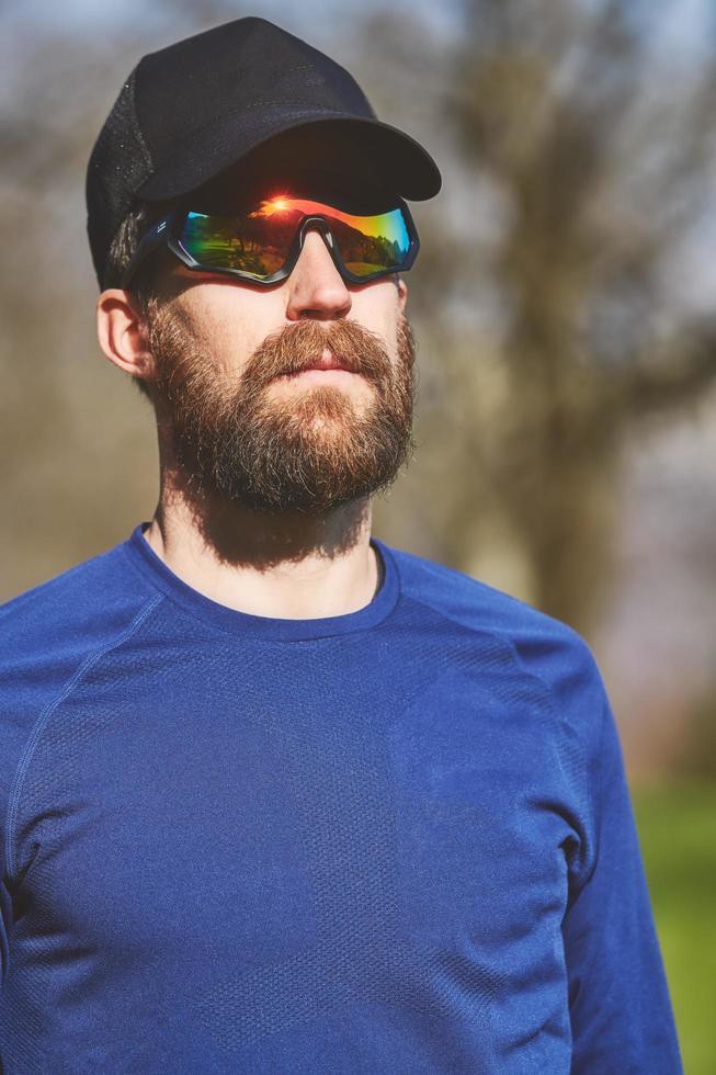 Portrait of young sporty man with beard with sunglasses photo