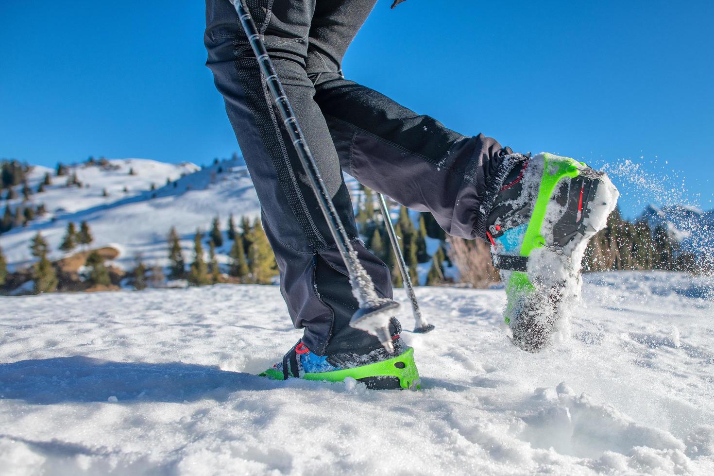 Detail of shoes in the snow with crampons during mountain walk in winter photo