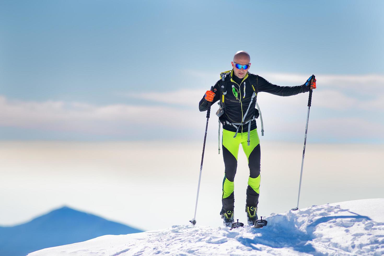 esquiador alpinista llegando a la cumbre foto