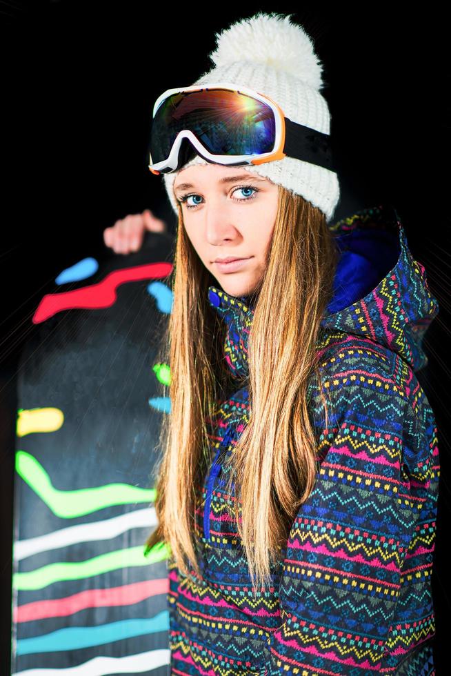 chica con snowboard fotografiada en el estudio con fondo negro foto