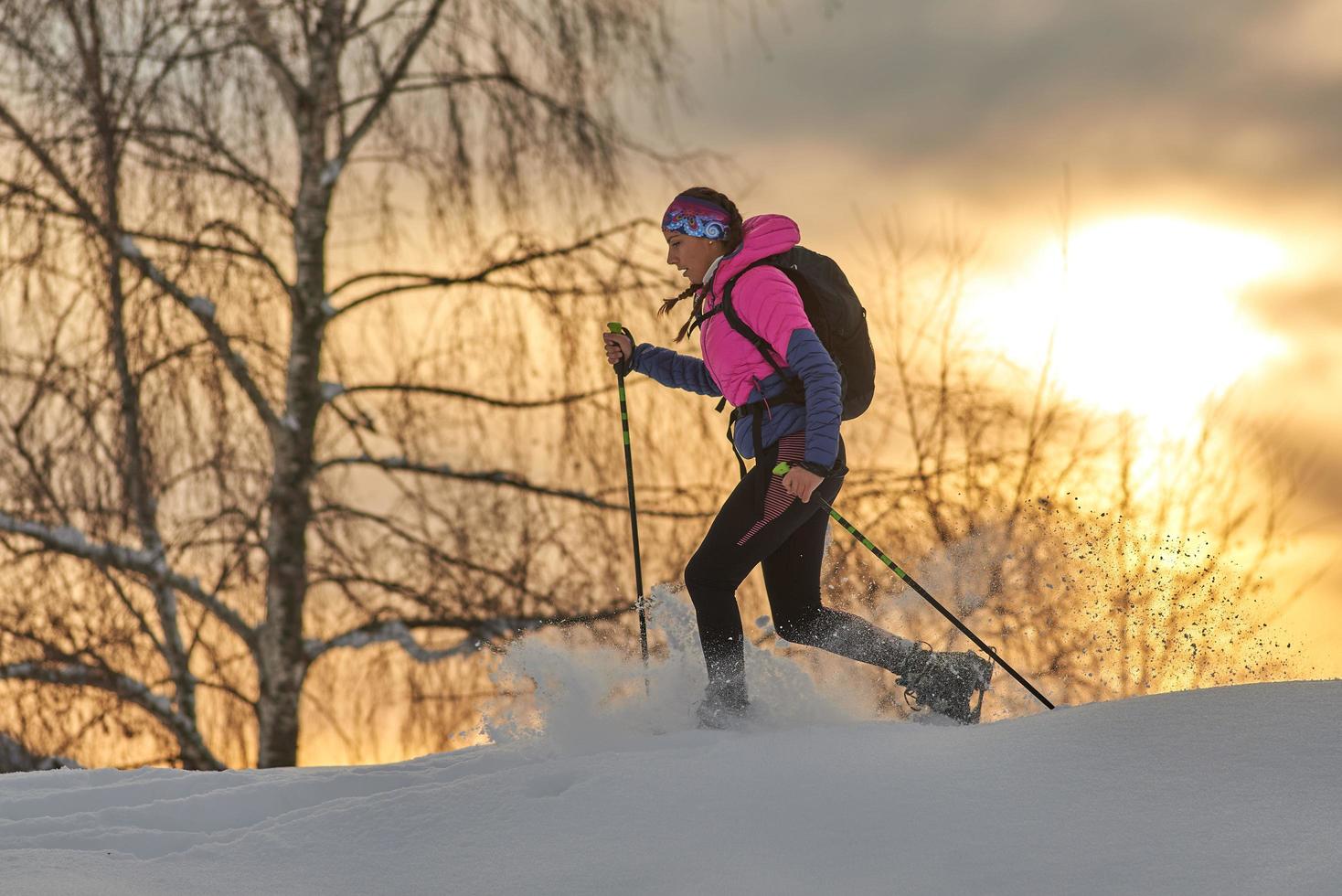 una joven deportista corre con raquetas de nieve foto