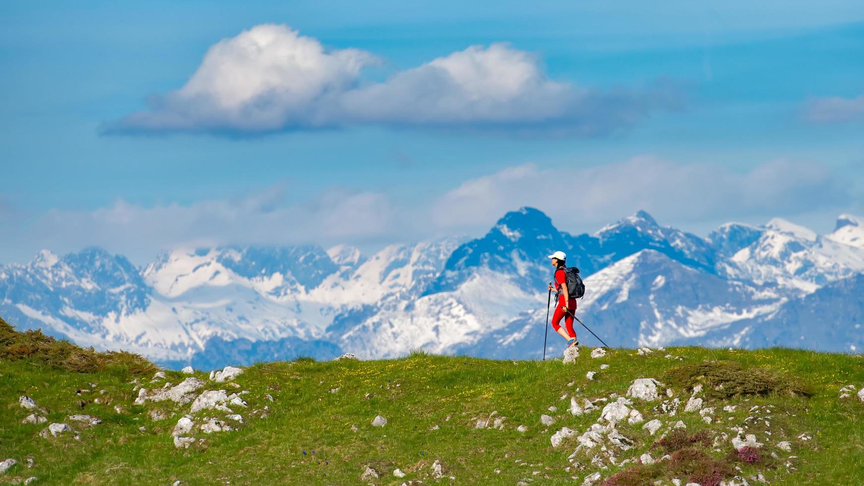 senderismo en las montañas una chica soltera con un paisaje de montañas cubiertas de nieve en la distancia foto