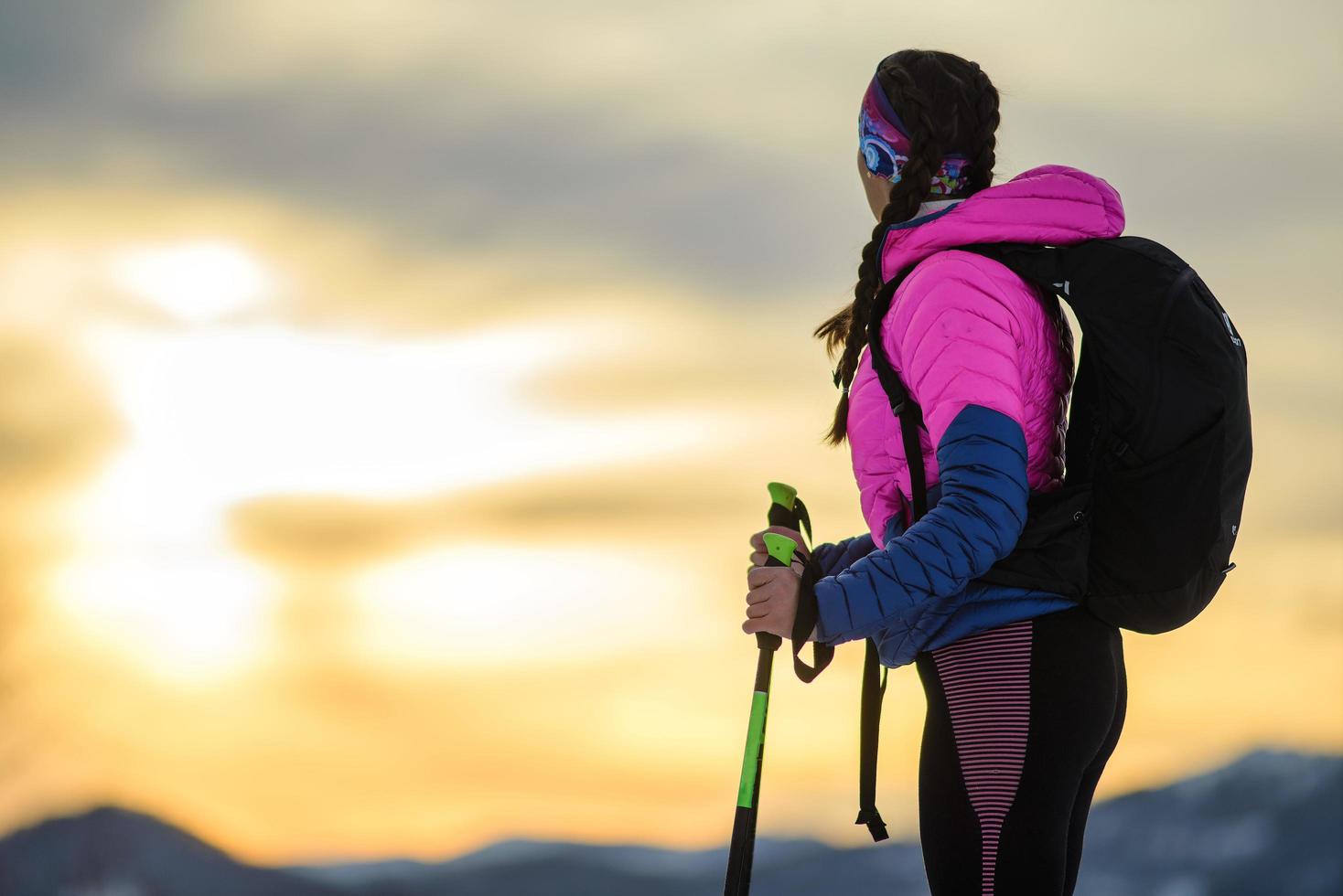 Girl observes the breathtaking sky during a winter alpine trek photo