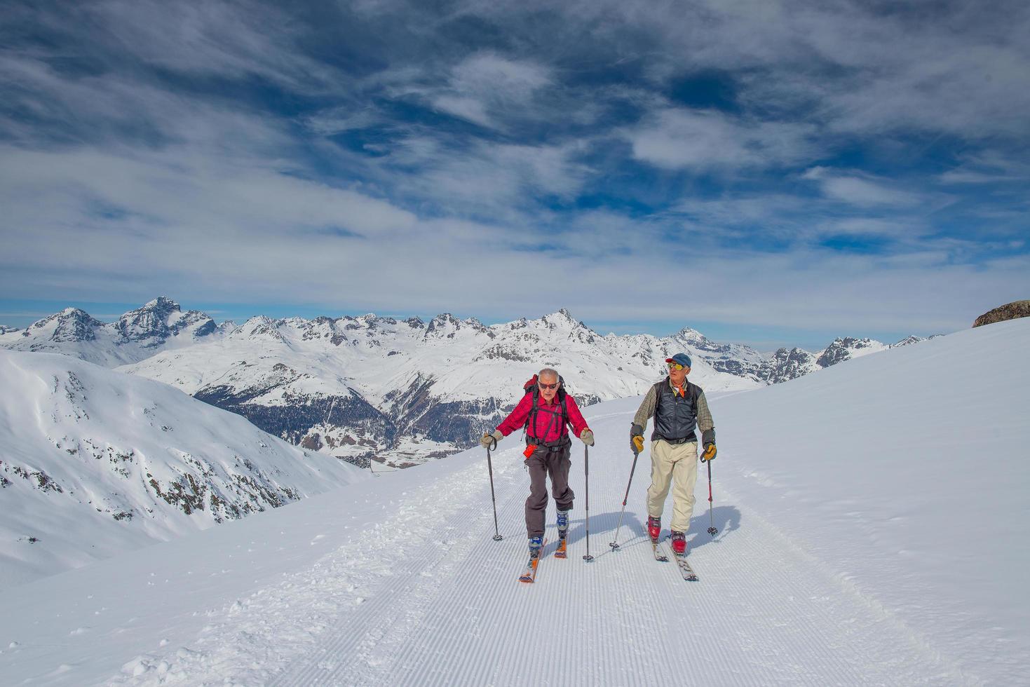 Two elderly men practice ski mountaineering photo