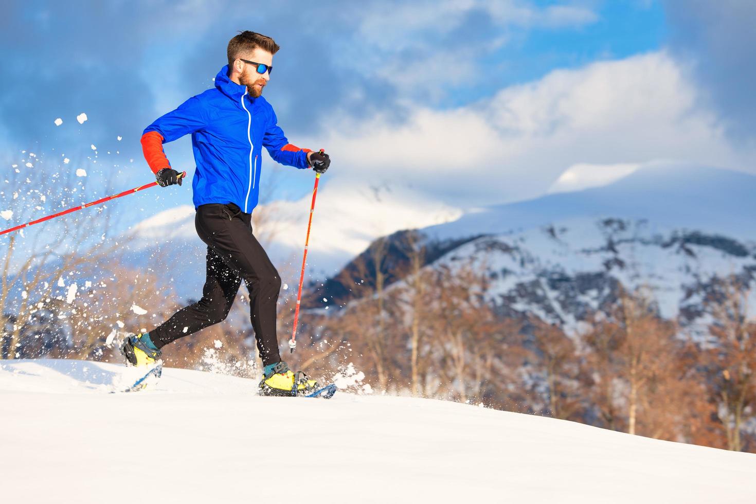 un atleta hombre entrena para correr con raquetas de nieve foto