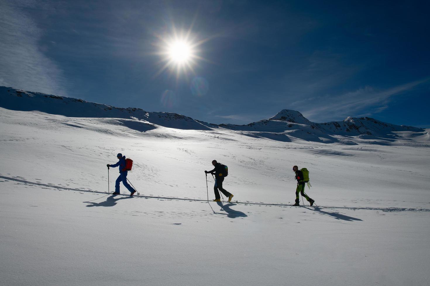 Rope of three ski mountaineers on a climb track photo