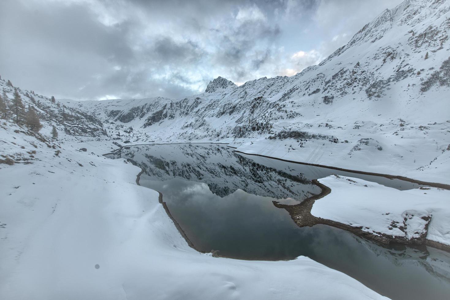 lago de alta montaña con la primera nevada foto