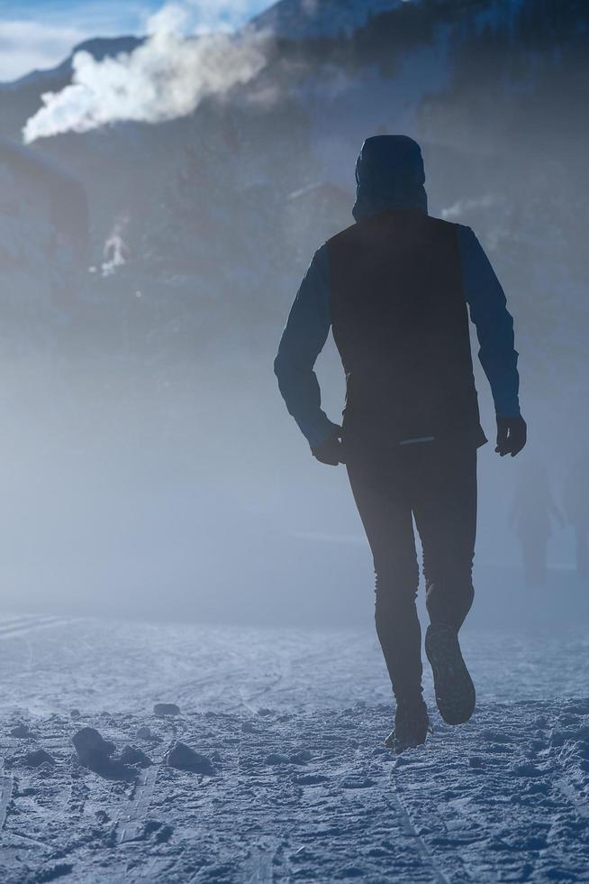 el hombre corre sobre la nieve en el frío invierno foto