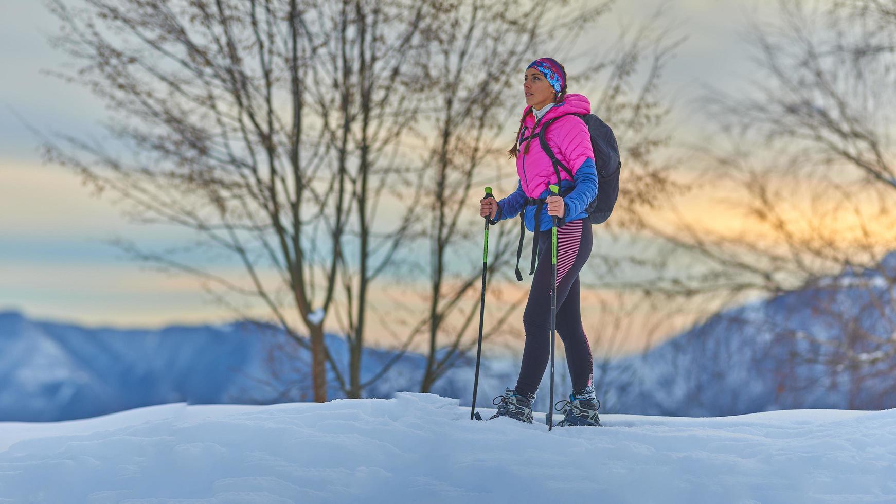 hermosa joven descansa durante una caminata con raquetas de nieve foto