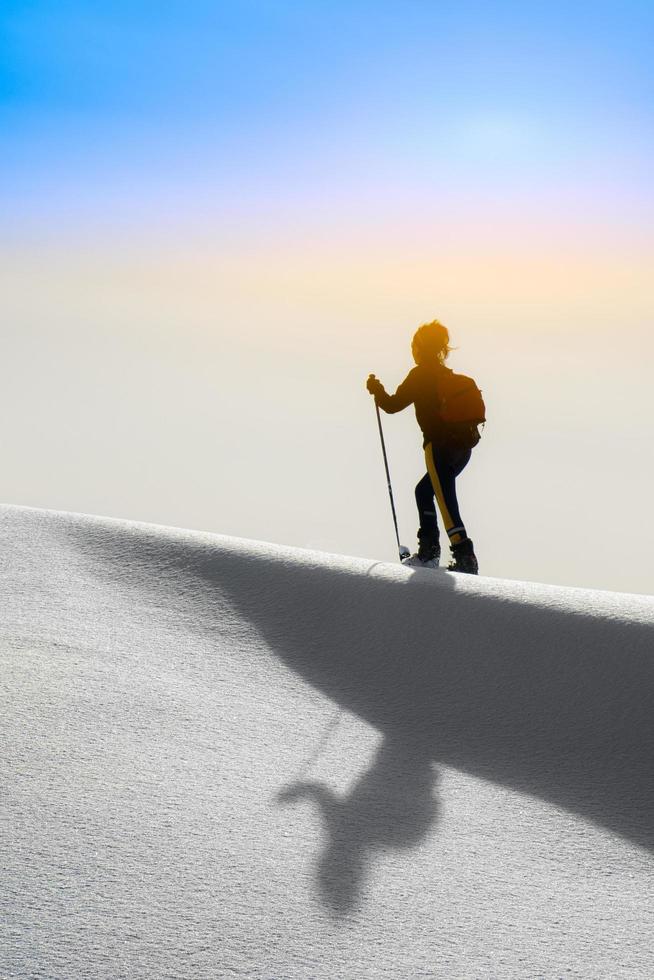 Girl silhouette with snowshoes photo