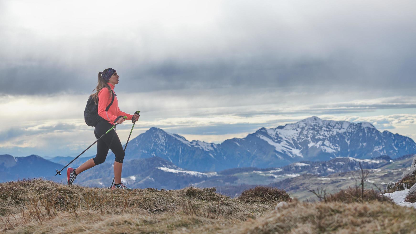 A Nordic walking girl walking alone in the mountains photo