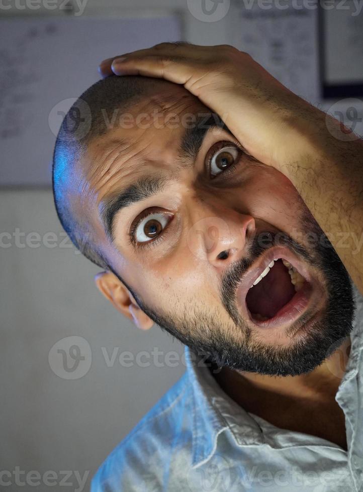 A bald young man shocked in front of camera photo