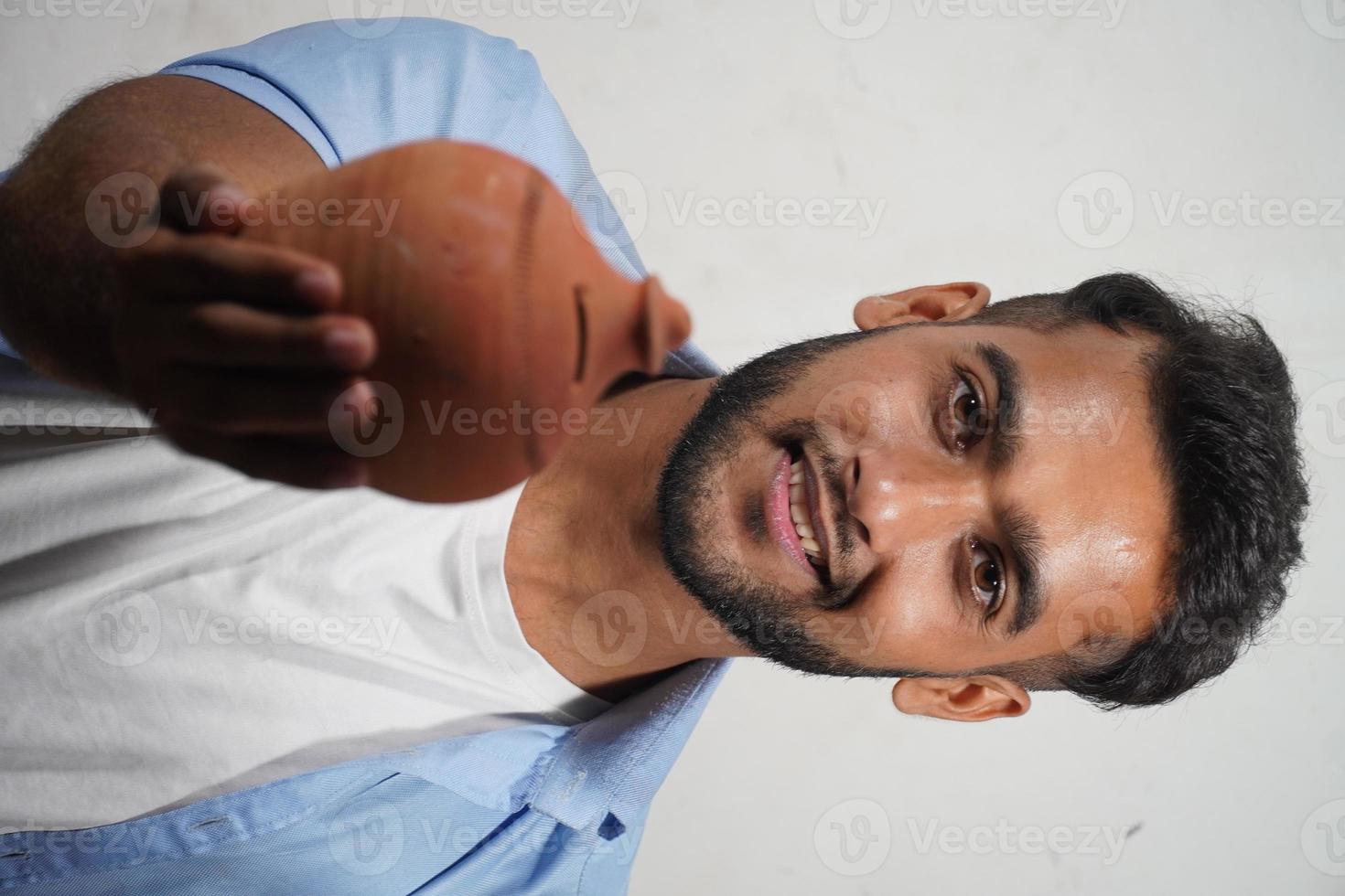 indian man showing his indian piggy bank photo