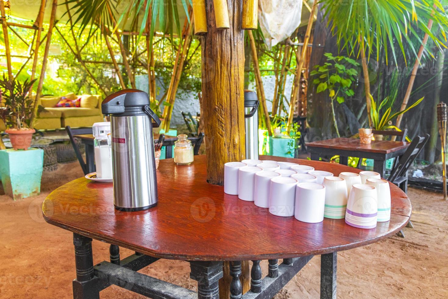 Coffee dispenser and cups on wooden table Holbox island Mexico. photo