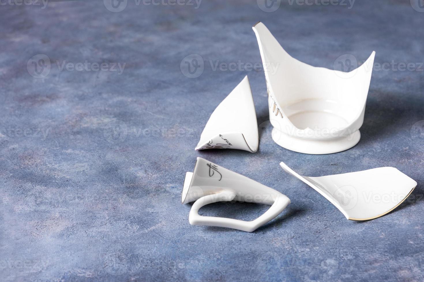 Fragments of white fragile porcelain cup photo