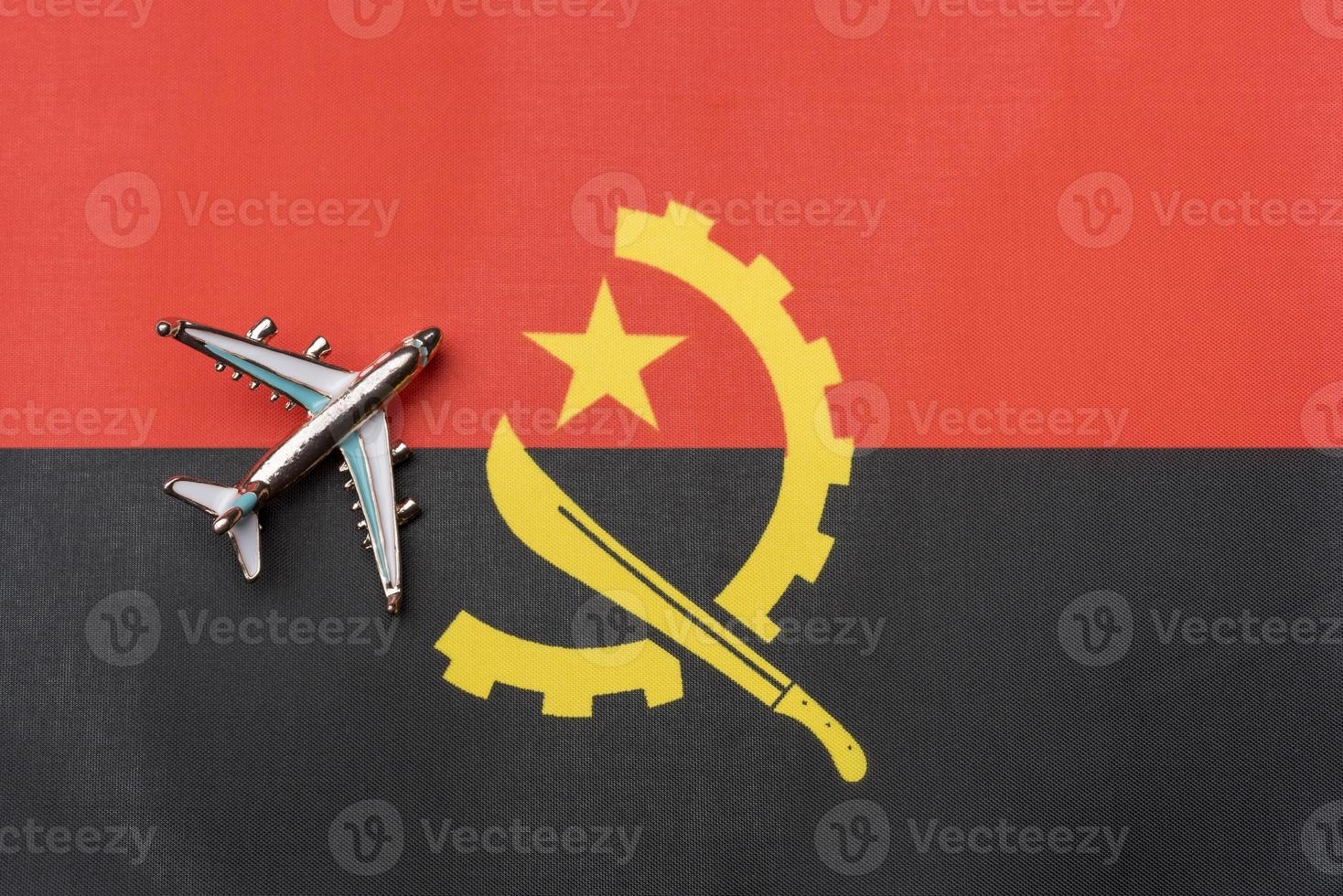 el avión sobre la bandera de angola, el concepto de viaje. foto