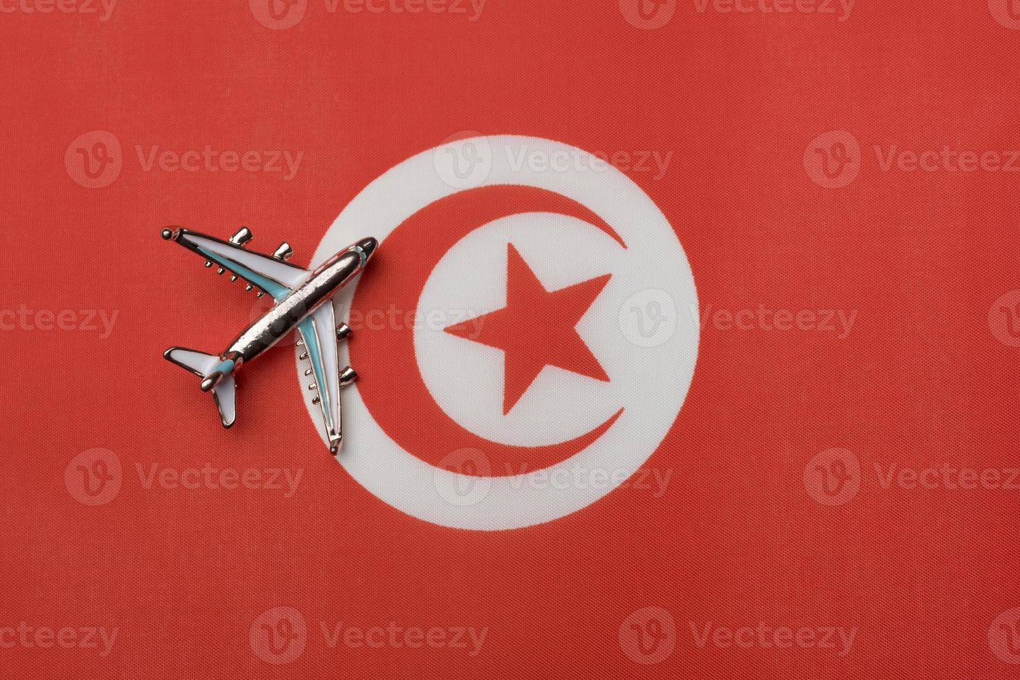 The plane over the flag of Tunisia, the concept of travel. photo