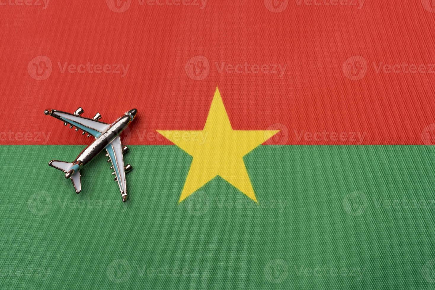 Plane over the flag of Burkina Faso, the concept of travel. photo