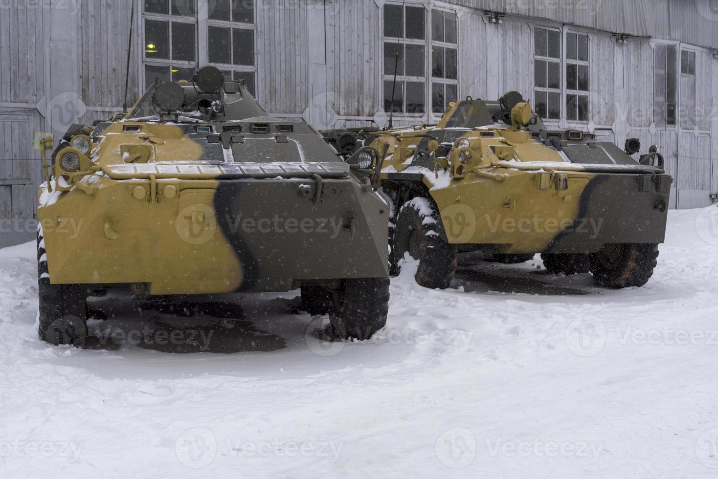 dos vehículos blindados se paran en el hangar en un día de invierno. foto