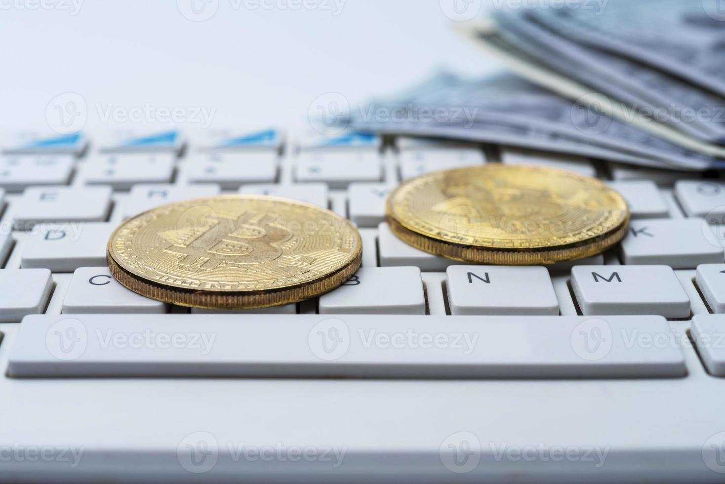 Bitcoin coin with keyboard and US dollars. Bitcoin gold coins on dollar banknotes office with a white background. photo