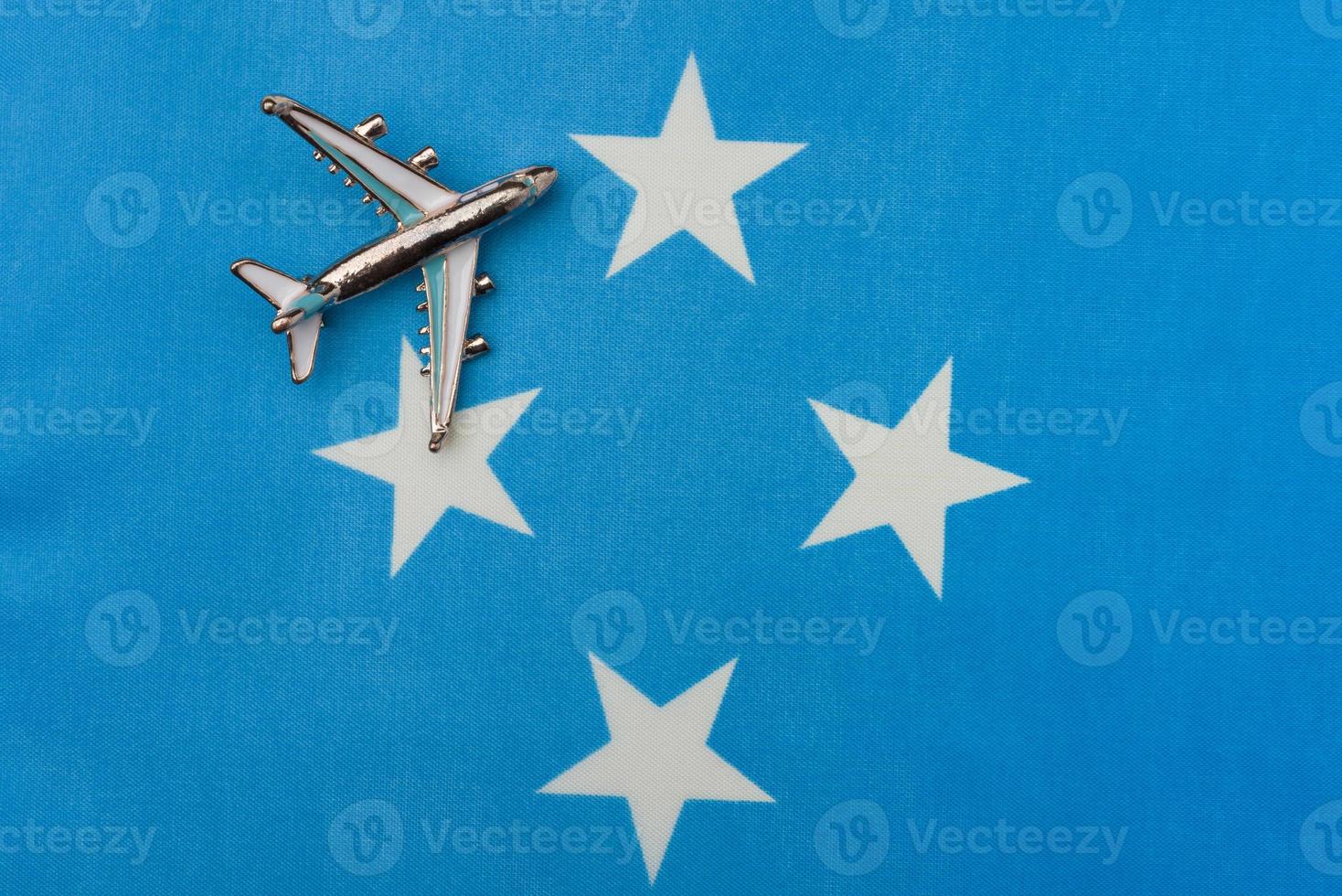 avión sobre la bandera de micronesia concepto de viajes y turismo. foto