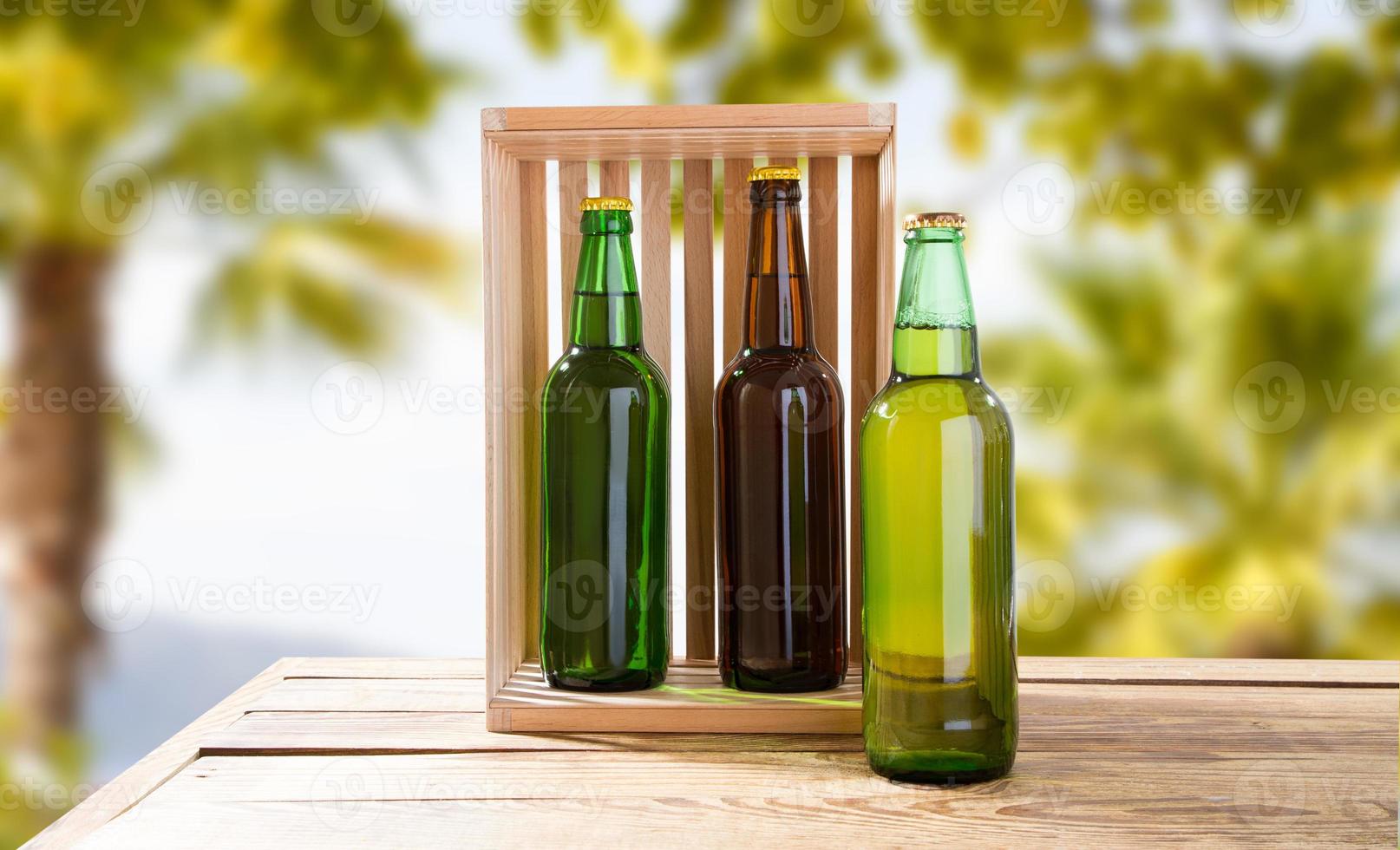 botellas de cerveza multicolores del autor en la mesa sobre fondo tropical borroso foto