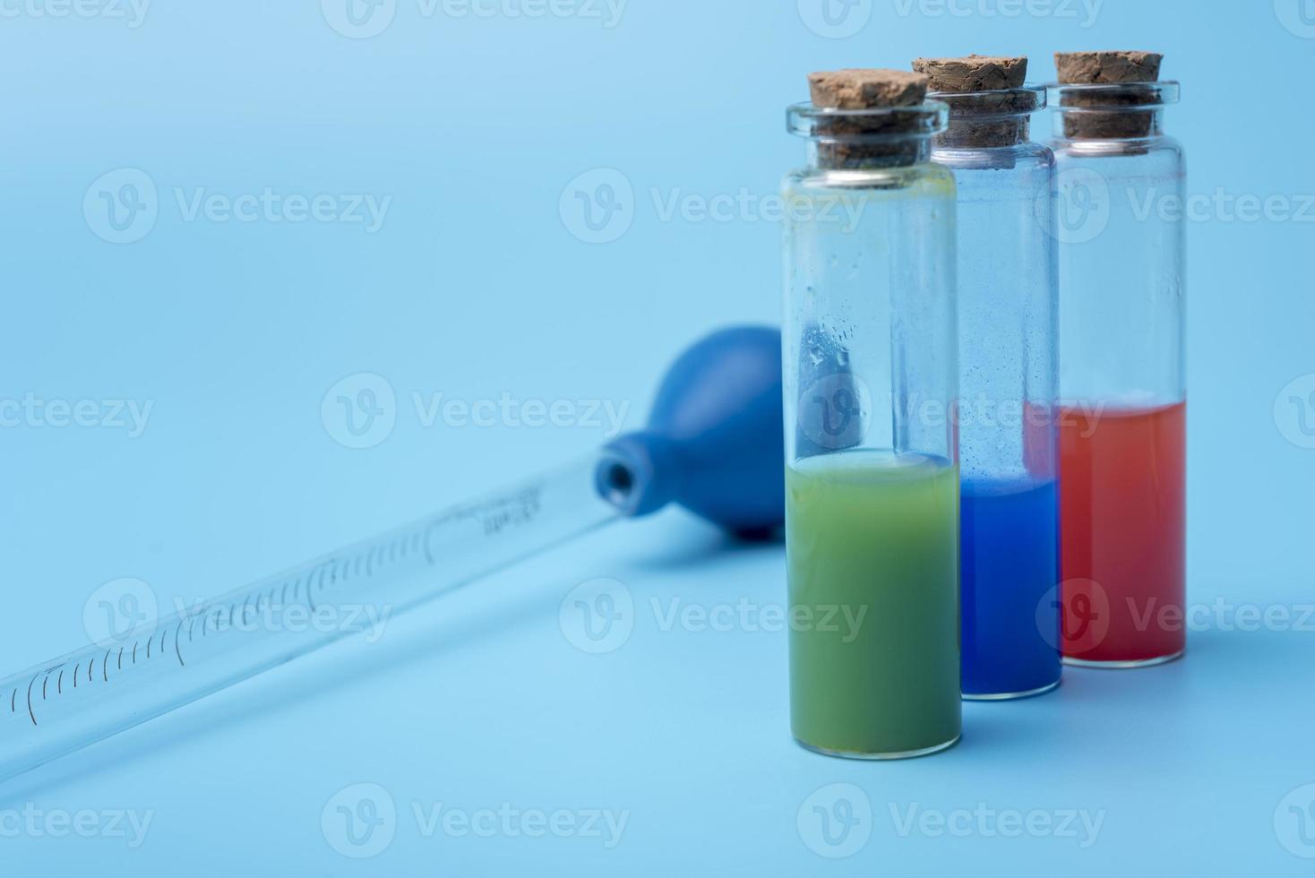 Tubes with different liquid inside on blue background. photo