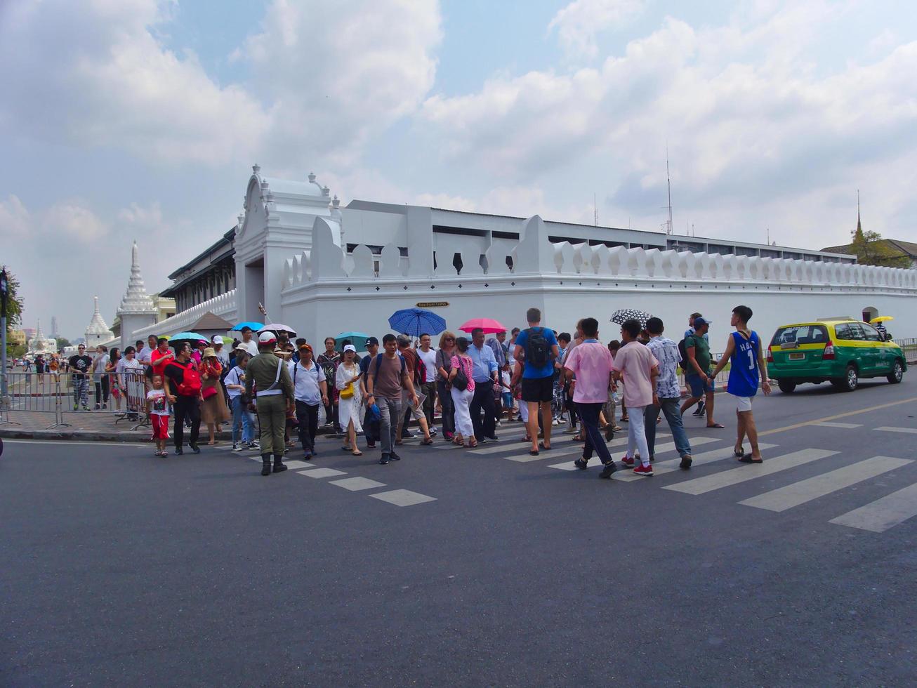 Wat Phra Kaew Temple of the Emerald BuddhaBANGKOK THAILAND15 FEBRUARY 2019Tourists walk around the area large groups showing red popular in this place..on BANGKOK THAILAND15 FEBRUARY 2019 photo