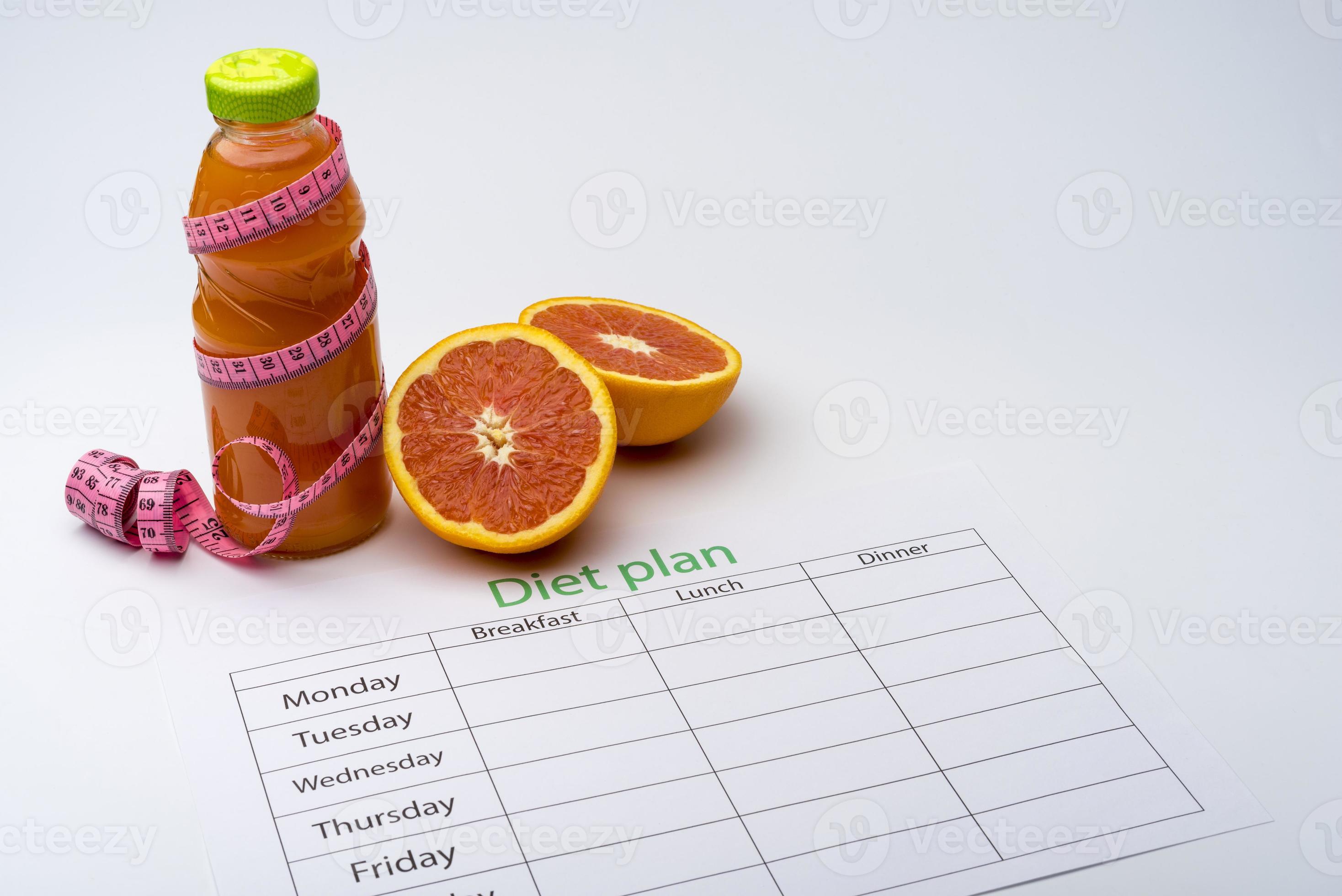 Diet plan and bottle of grapefruit juice with fresh grapefruit on white