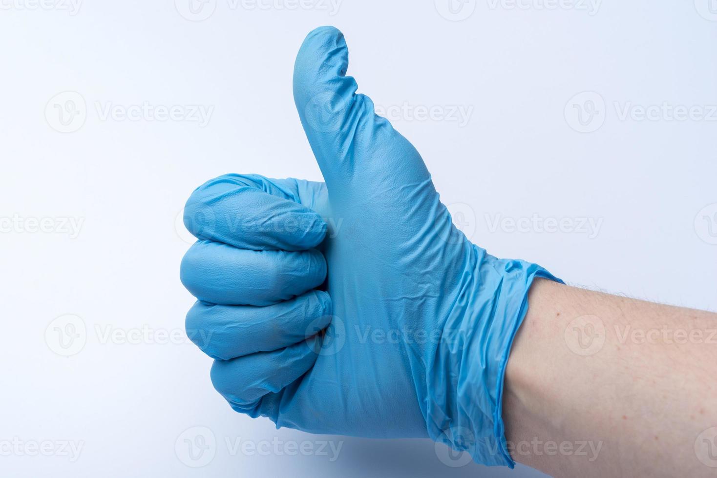 The gloved hand shows the thumbs up. photo